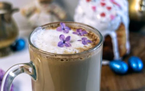 Pouring milk into coffee with Easter cake and plush bunny on background. 库存照片