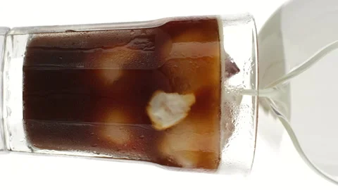 Pouring milk in coffee ice. Making  iced coffee with milk Stock Footage 243644264