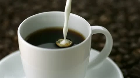 Pouring milk into coffee, Slow Motion Stock Footage 12579143