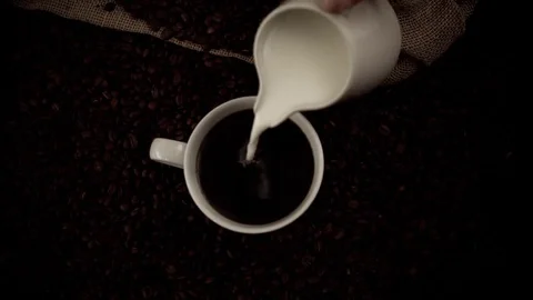 Pouring milk in coffee in slow motion Stock Footage 76100722