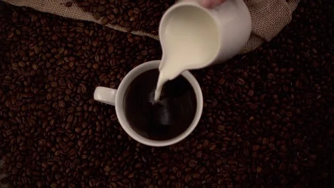 Pouring milk in coffee in slow motion Stock Footage 76100730