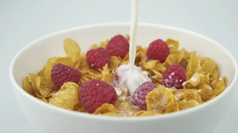 Pouring milk on corn flakes with raspberries Vidéo 233167120