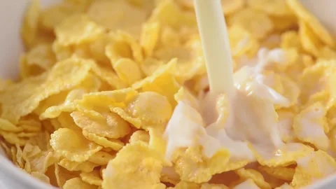 Pouring milk to the corn flakes into the white bowl. Macro slow motion Stock Footage 171721731