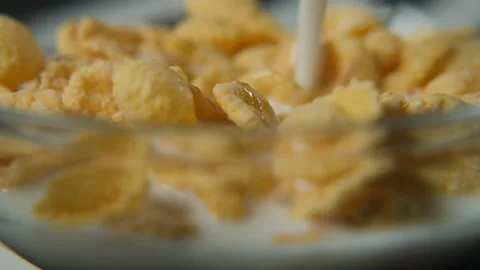 Pouring milk into cornflakes breakfast macro view Stock Footage 321953979