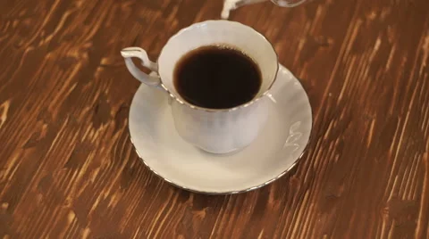 Pouring milk into a cup of coffee. Stock Footage 68645140