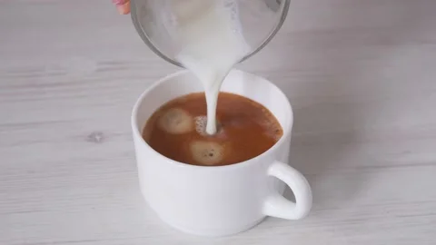 Pouring milk in cup of coffee Stock Footage 232131415
