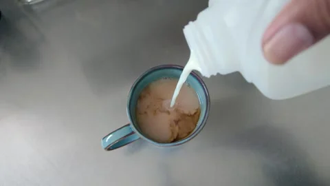 Pouring Milk into a Cup of Tea Stock Footage 326374850