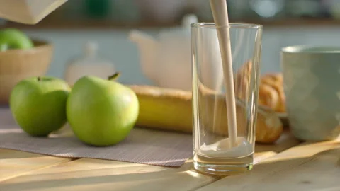 Pouring milk into the glass on breakfast table. Commercial shot Stock Footage 196708375