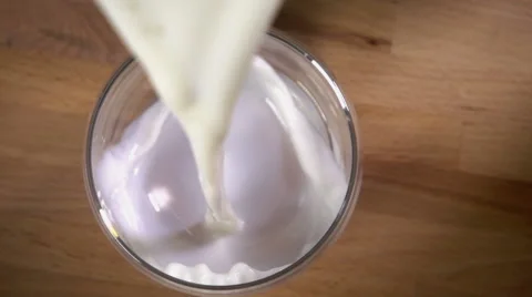 Pouring milk into glass, slow motion overhead Stock Footage 55225715