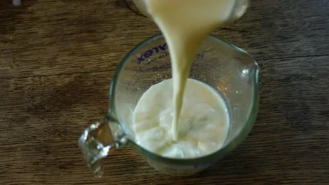 Pouring Milk into a Measuring cup Stock Footage 201699712