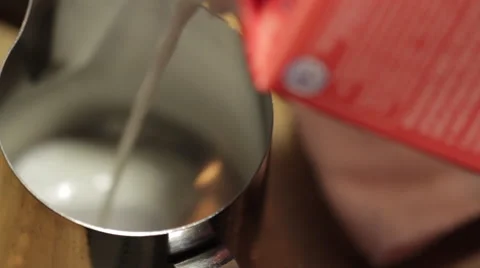 Pouring milk from a package into a jug  Видео 58861837