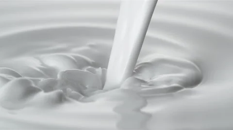 Pouring milk into swirl of milky liquid. Stock Footage 65376853
