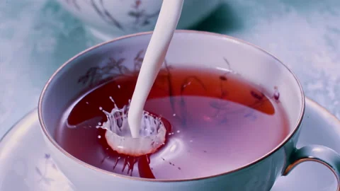 Pouring Milk in Tea Cup on the Table Super slow motion 1000fps Stock Footage 130985213