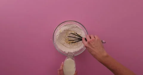 Pouring in milk while whisking 1 Stock Footage 132148696