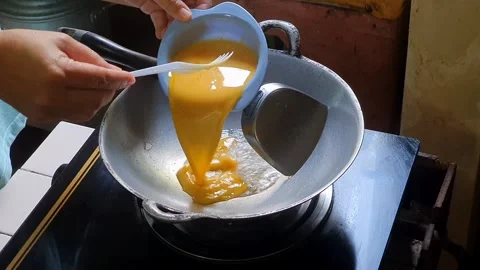 Pouring mixed egg or beaten egg or whisked egg into the frying pan on the l.. Stock Footage 279294537