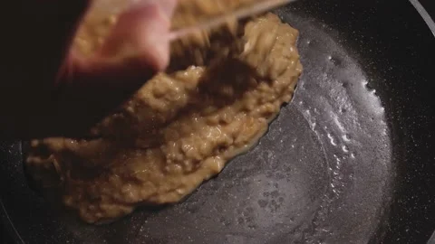 Pouring the mixture of oatmeal, eggs, cheese and milk into a heated pan Stock Footage 166356391