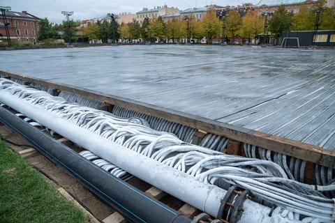 Pouring of modern engineering system hoses for skating rink cooling. Preparation 스톡 사진