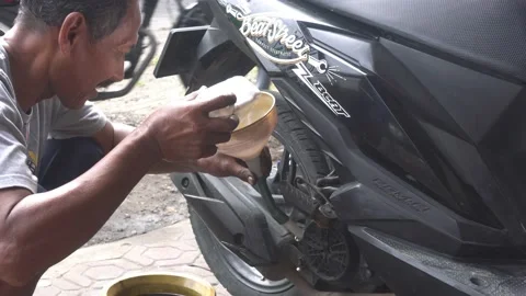 Pouring the motorcycle oil machine using plastic funnel Video stock 232471297