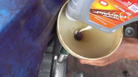 Pouring the motorcycle oil machine using plastic funnel Stock-Footage 232471821