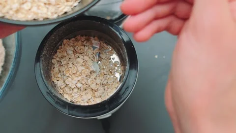 Pouring oatmeal into a coffee grinder Stock Footage 252527700