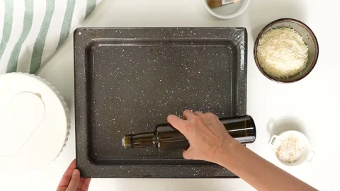 Pouring olive oil into baking sheet. Video stock 119954780