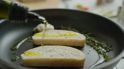 Pouring Olive Oil Over Bread Slices in Frying Pan Stock Footage 249825696