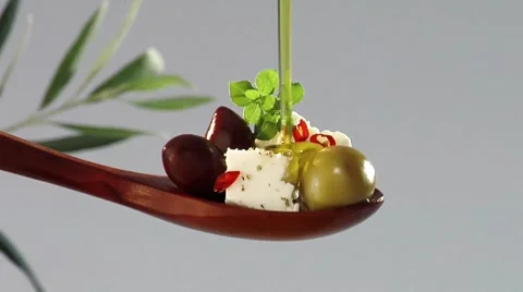 Pouring olive oil over feta and olives Stock Footage
