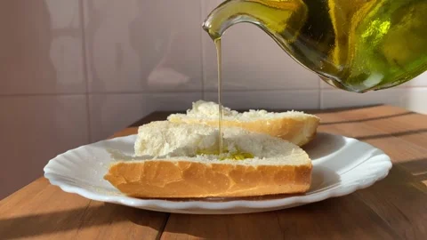 Pouring olive oil over some slices of bread. Stock Footage 220034305