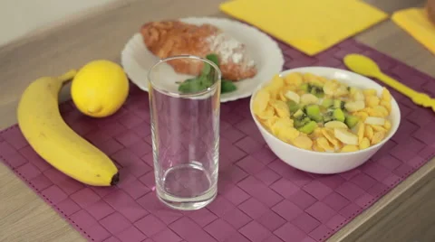 Pouring orange juice in glass at breakfast Stock Footage 59605138