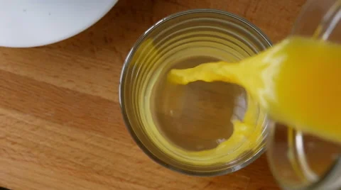 Pouring orange juice, overhead view, slow motion Stock Footage 49200519