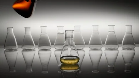 Pouring orange liquid into erlenmeyer flask Stock Footage 123345223