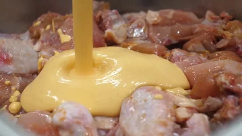 Pouring Orange Marinating Sauce or Batter Onto Raw Chicken Pieces in a Bowl Video stock 343028551
