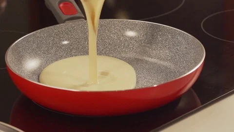 Pouring pancake dough in a pan out of a dipper Stock Footage 81817286