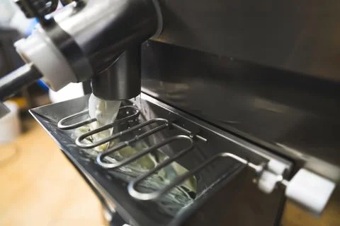 Pouring pasteurized ice cream formula out of batch machine Stock Photos