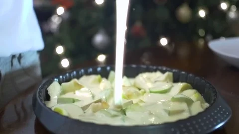 Pouring pastry on sliced apples on a baking plate - closeup Stock Footage 70705345