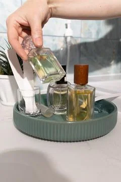 Pouring perfume from a rectangular bottle into a glass on a luxury vanity Stock Photos