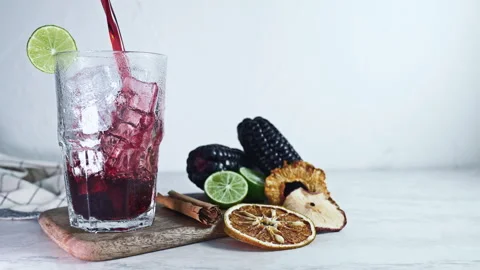 Pouring Peruvian Chicha Morada, Purple Corn Drink with Lime and Cinnamon Stock-Footage 344175525
