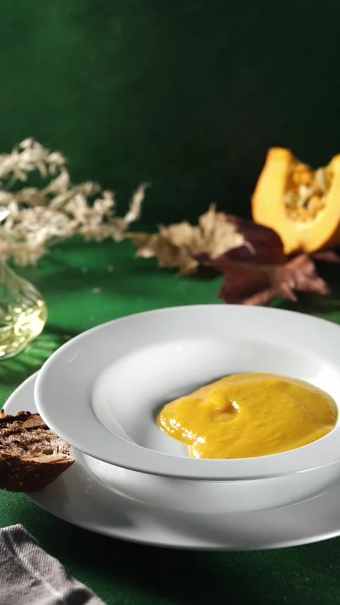 Pouring pumpking soup in a plate Stock Footage 247707318