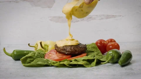 Pouring Queso Over a Bunless Hamburger Stock Footage 141023846