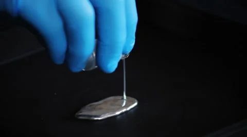 Pouring Quicksilver on black surface Stock Footage 61817593