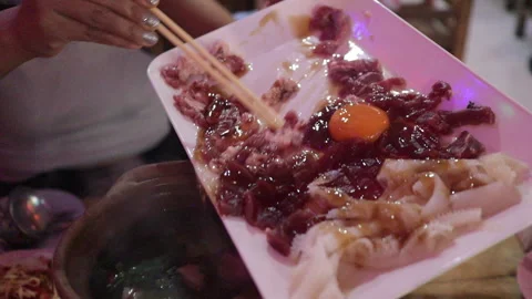Pouring Raw Beef, Tripe &amp; Egg In Soup Broth, Asian Thai Hotpot Sukiyaki, Jim Jum Stock Footage 240450978