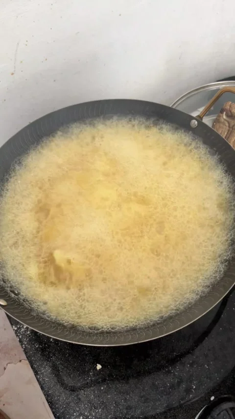 Pouring Raw Egg Into Hot Pan Reflecting Kitchen Lighting Stock Footage 340011741