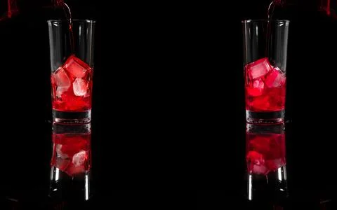 Pouring red alcoholic cocktail solution on the top of the ice into the clean  Stock Photos