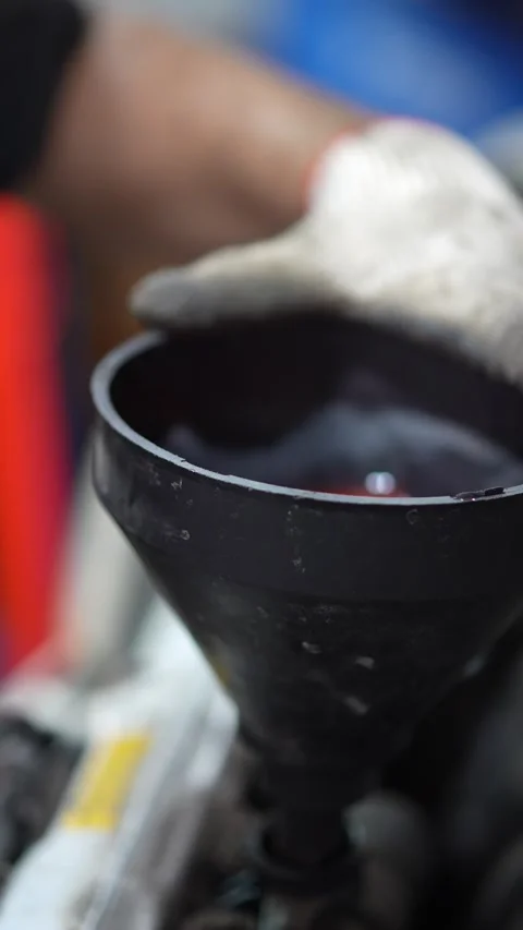 Pouring Red Liquid into Funnel - Garage Workshop Scene Stock Footage 345568851