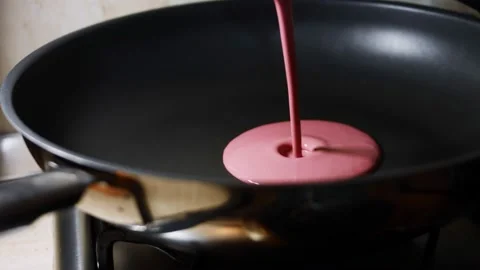 Pouring red pancake batter in a pan for cooking pancakes. Process of preparing Stock Footage 144904670