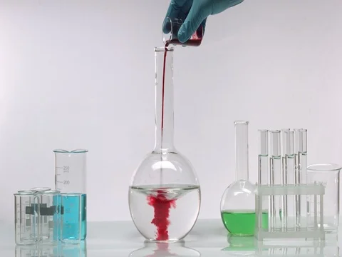 Pouring red solution in transparent liquid Stock Footage 69779352