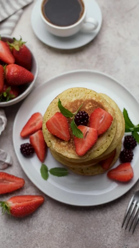 Pouring red syrup over pancakes with berries Stock Footage 336258156