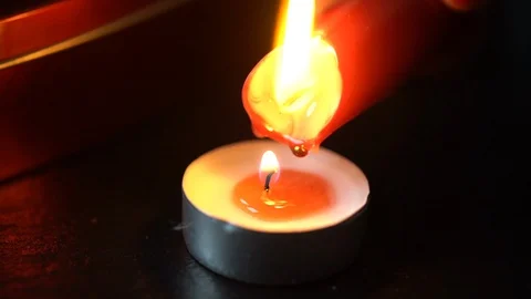 Pouring red wax from a candle into a tea light Stock Footage 124297625