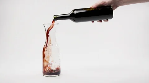 Pouring red wine from bottle into decanter on white clean background.  Stock Footage 102724009