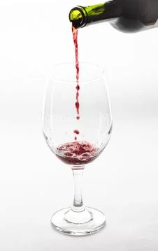 Pouring red wine into empty glass isolated on white background Stock Photos